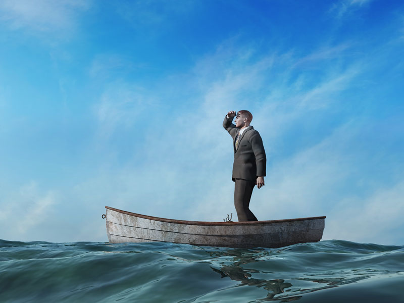 Businessman standing on boat looking out to the distance for help