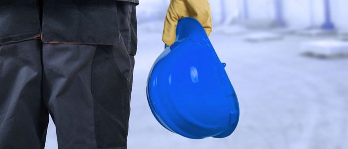 Construction worker holding a blue safety helmet