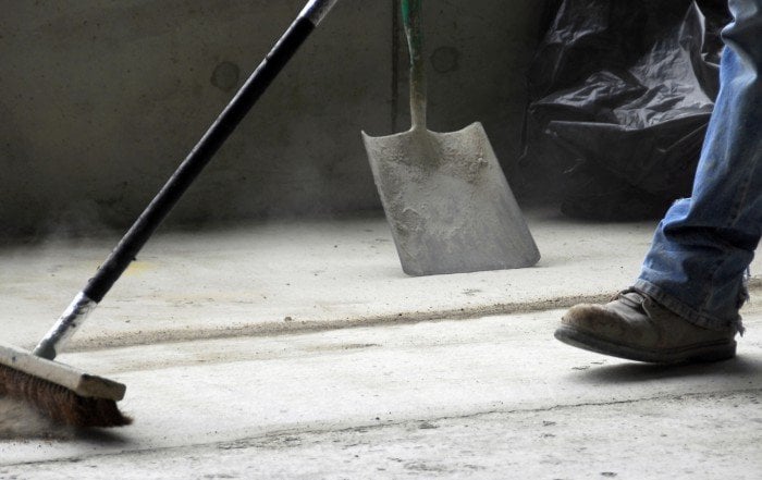 Travailleur balayant un chantier.