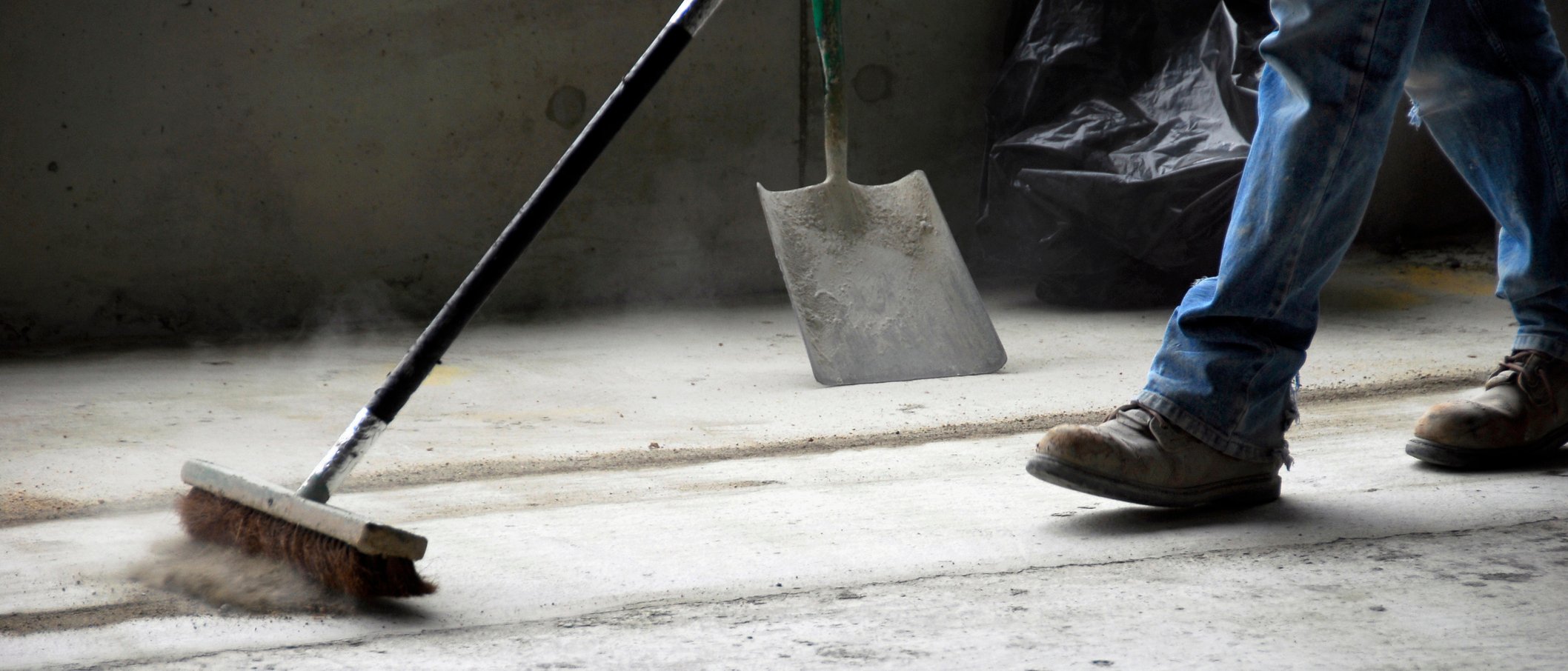 A construction worker sweeping.