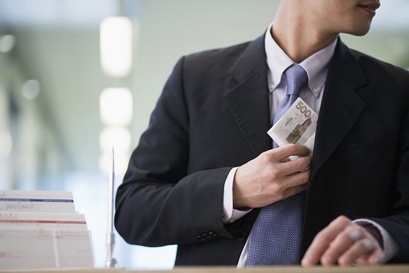 Photo d’un employé volant de l’argent à son entreprise.