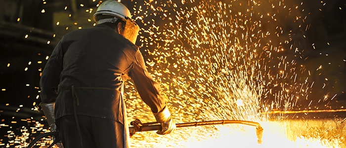 Worker welding metal with sparks flying around
