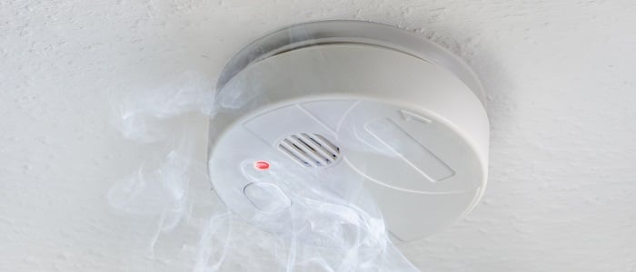 Close up of a white smoke alarm detecting smoke