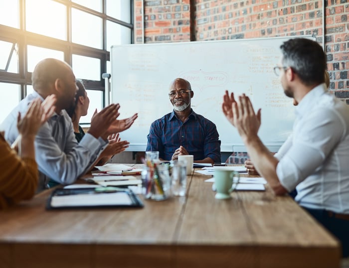 colleagues applauding coworker