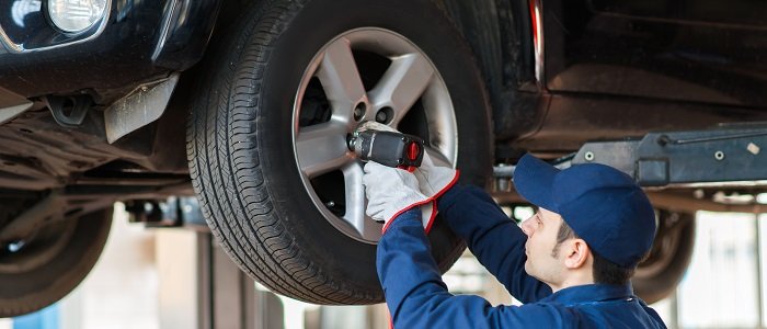 Photo d’un mécanicien changeant le pneu d’un véhicule.