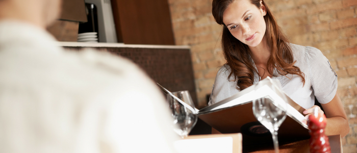 Woman in a restaurant considering menu options.