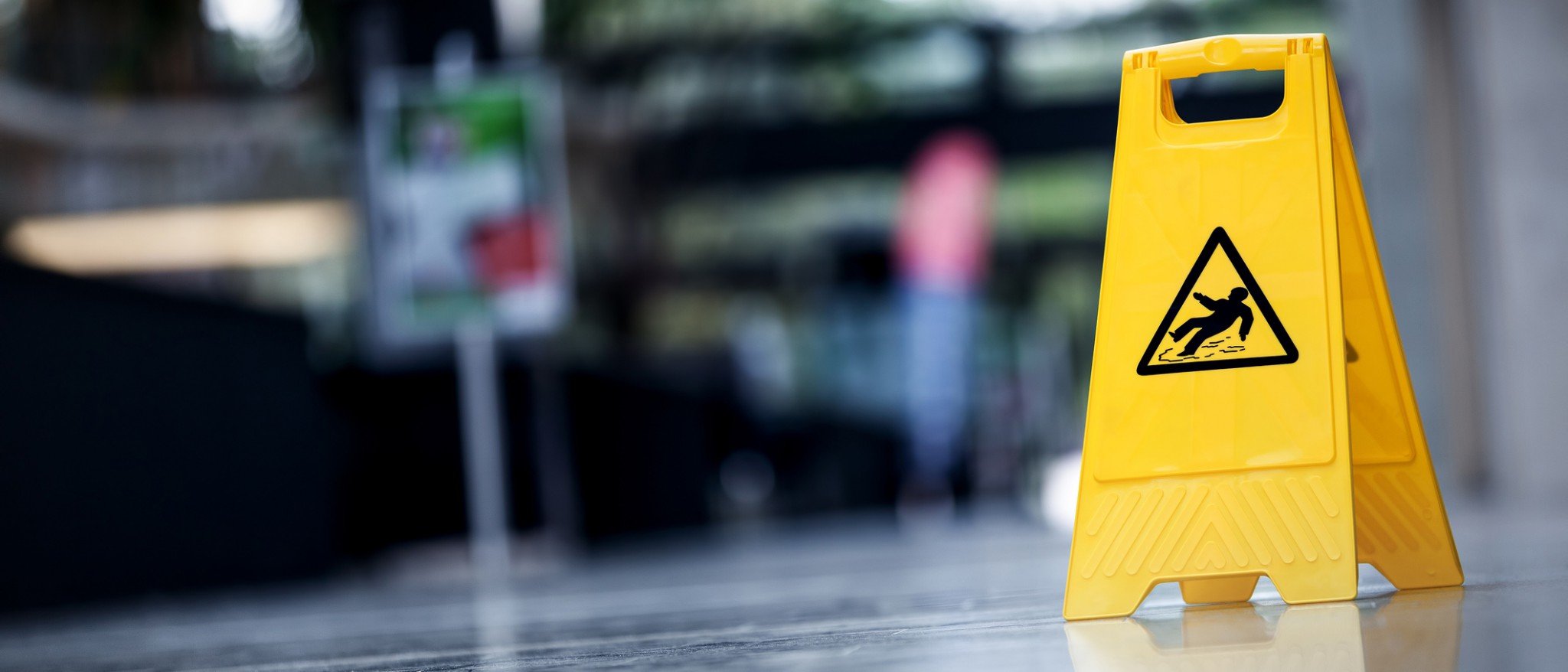 Yellow wet floor sign warning about slips and falls in the area