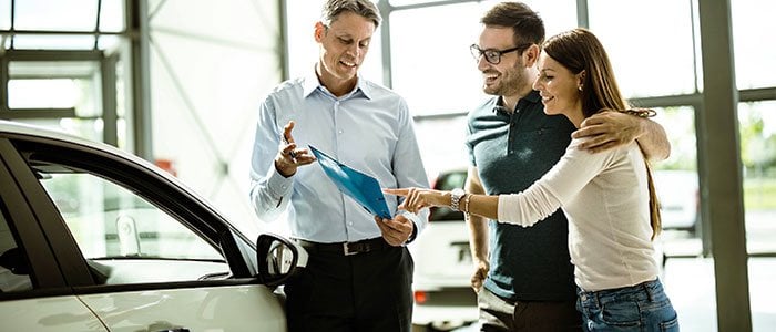 Male auto dealer selling cars to client