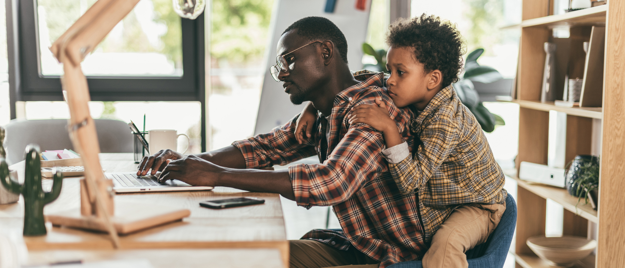 Man working from home while taking care of his son