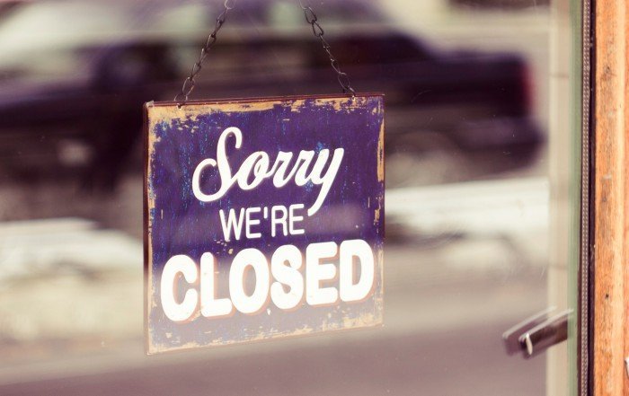 Sorry we're closed sign hung on the store's entrance door