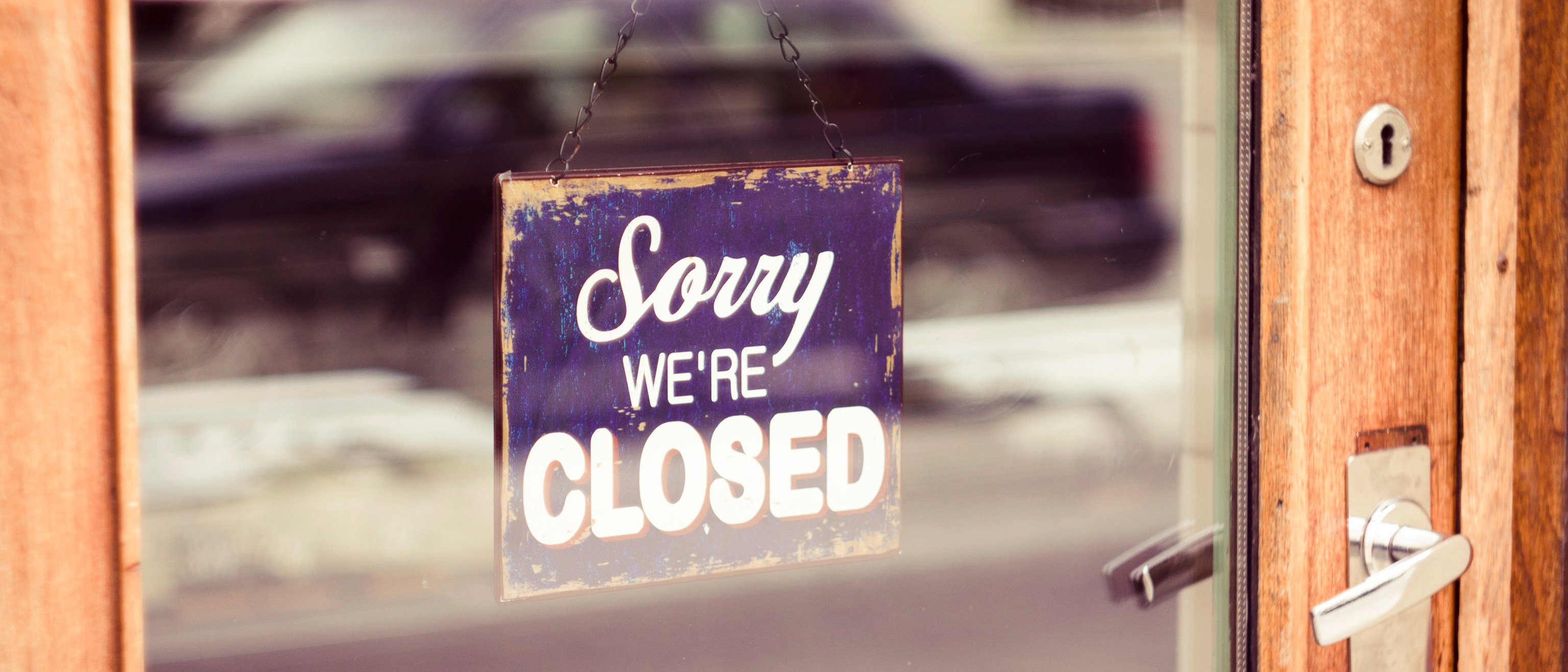 Sorry we're closed sign hung on the store's entrance door