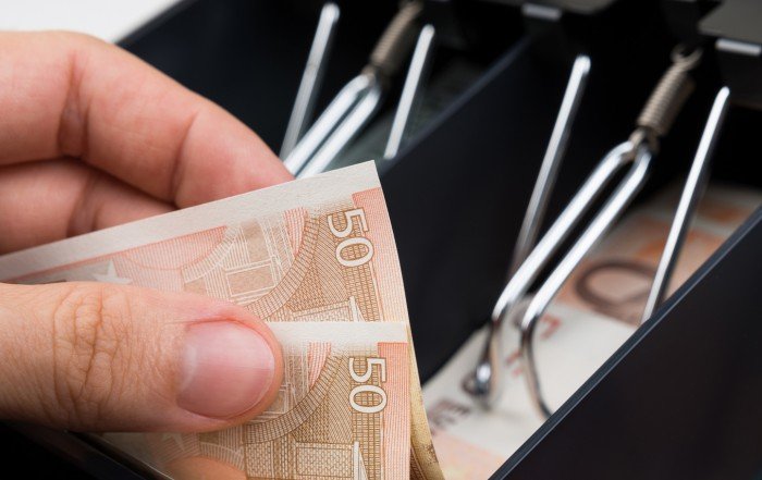 Close up of cashier taking out cash from the register