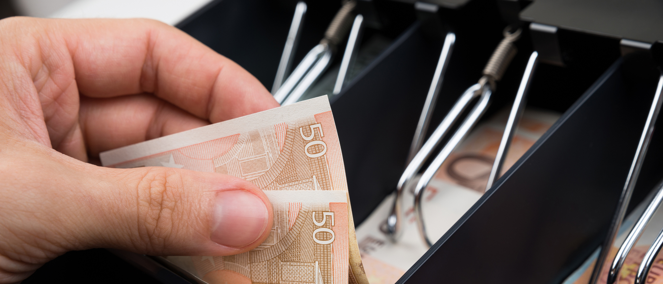 Close up of cashier taking out cash from the register