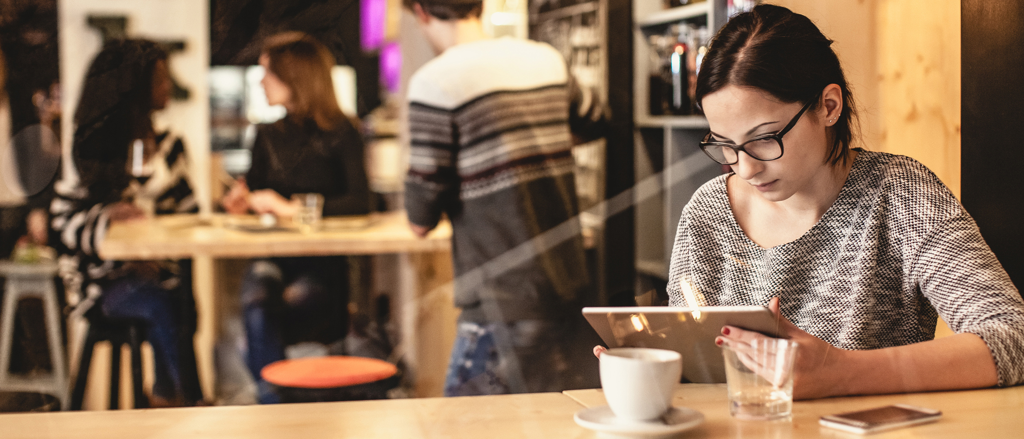 Female customer at restaurant sitting by window on her tablet