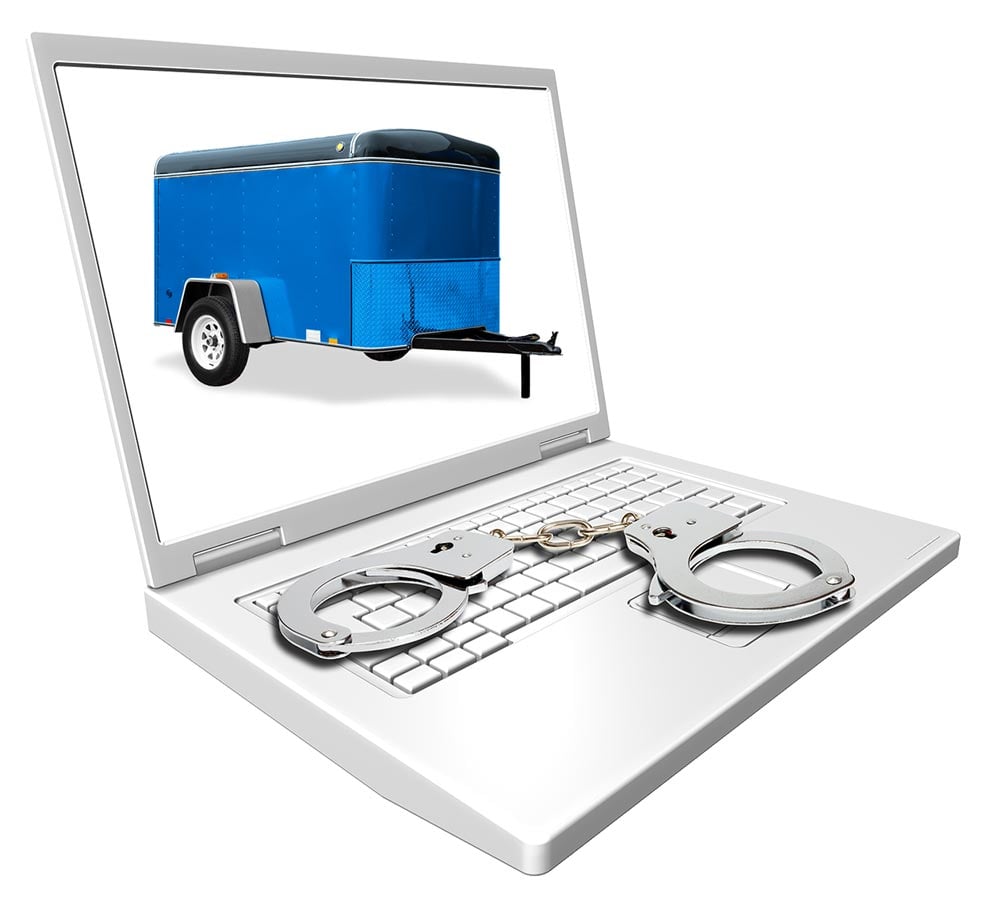 Laptop displaying a truck end with handcuffs resting on top of keyboard