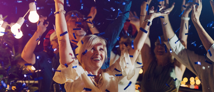 woman with hands up and blue confetti falling down