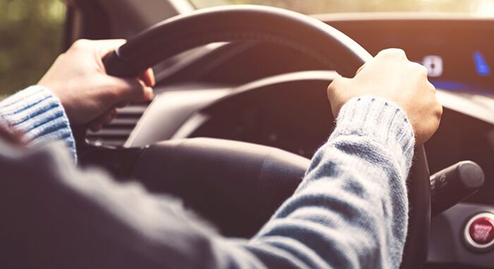 person behind the wheel of a car