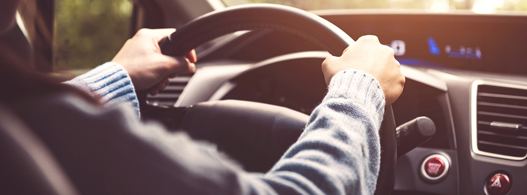 person behind the wheel of a car